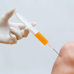 Doctor doing stem cell therapy on a knee with platelet-rich plasma injection.